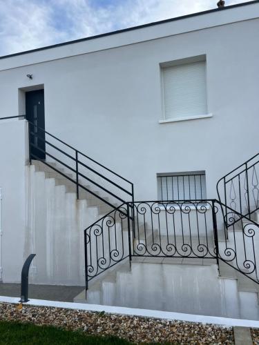 a white building with stairs and a window at Appartement moderne et spacieux 4 in Carbon-Blanc