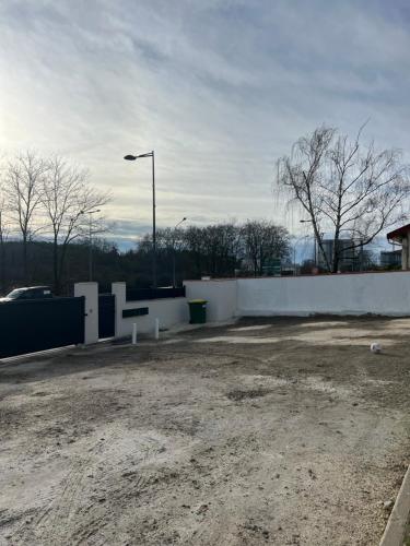 a parking lot with a white wall and a street light at Appartement moderne et spacieux 4 in Carbon-Blanc