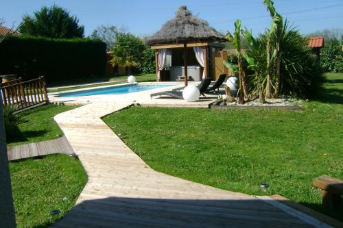 a path leading to a swimming pool with a gazebo at Gîte & Chambres d'Hôtes - Le Petit Bali in Saint-Pandelon