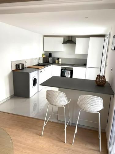 - une cuisine avec 2 chaises et un comptoir dans l'établissement Appartement Juan Les Pins à 700 m des plages, à Antibes