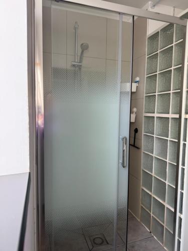 une douche avec une porte vitrée dans une salle de bain dans l'établissement La Bulle d R, au Tréport