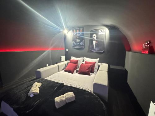 - une chambre avec un lit dans une pièce éclairée dans l'établissement CinemaRoom - Netflix -Hyper Centre, à Arras
