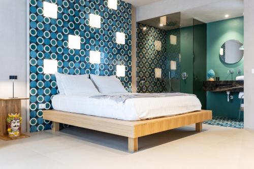 a bedroom with a bed and a green wall at Oikos Rooms in Marsala