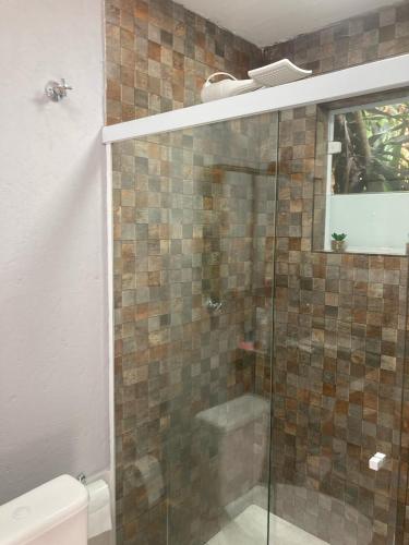 a bathroom with a glass shower with a toilet at Chalé 2 - Lateral in São Bernardo do Campo