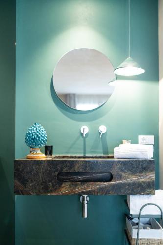 a bathroom with a sink and a mirror at Oikos Rooms in Marsala