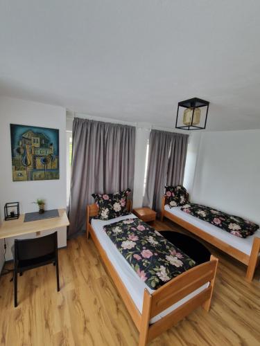 a room with two beds and a desk and a bed at Kleine Zimmer in Gästehaus in Feldkirch