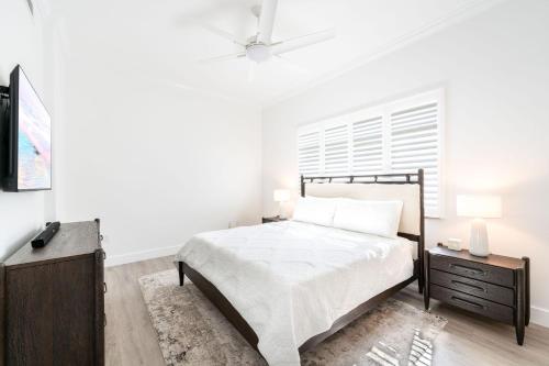 une chambre blanche avec un lit et une télévision dans l'établissement South Bay Beach Club #1 - 2 Bedroom 2 Bathroom Unit, à Dog City