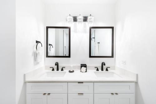 - une salle de bains blanche avec deux lavabos et deux miroirs dans l'établissement South Bay Beach Club #1 - 2 Bedroom 2 Bathroom Unit, à Dog City