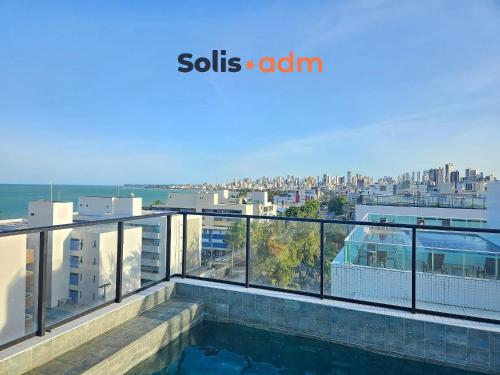 a balcony with a view of a city at Studio espaçoso e confortável a 50m da praia in Tambaú