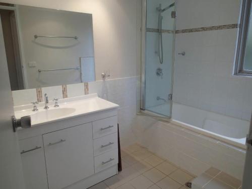 a white bathroom with a sink and a shower at Aalen Endangered Species in Jindabyne