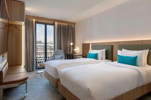 a hotel room with two beds and a balcony at Courtyard by Marriott Biel Bienne in Biel