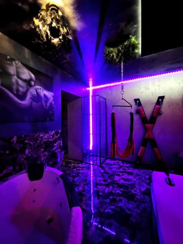 a room with purple lighting and a tub with a swing at Love Room in Bucharest