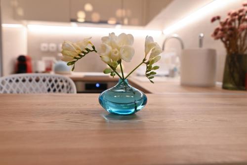 a blue vase with flowers in it on a table at Lilaki in Larisa
