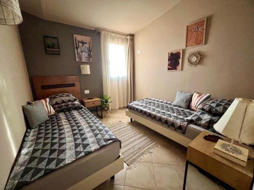 a bedroom with two beds and a table with a lamp at Tropical Morna in Santa Maria