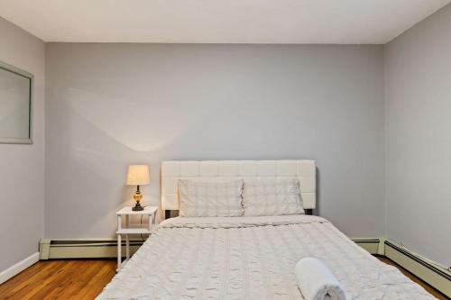 a white bedroom with a large bed and a lamp at Big House, Hot tub, Very large backyard in Stony Point