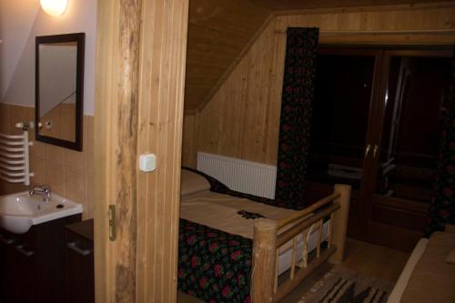 a small room with a bunk bed and a sink at Chata Pod Grapom in Czarna Góra