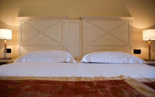 a bedroom with a large bed with two pillows at Hotel Villa Cappugi in Pistoia
