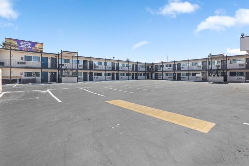 an empty parking lot in front of a building at Inland Inn & Suites in San Bernardino