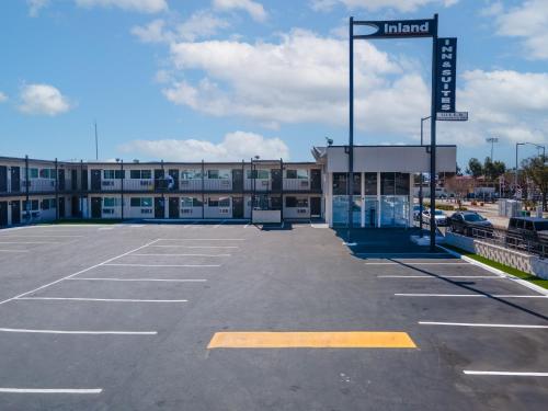 an empty parking lot in front of a building at Inland Inn & Suites in San Bernardino