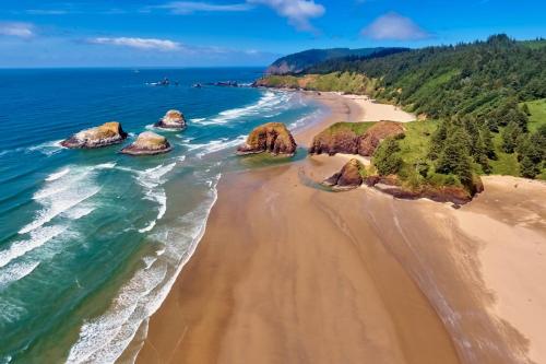 an aerial view of a beach with rocks in the ocean at Seaside Serenity. in Seaside