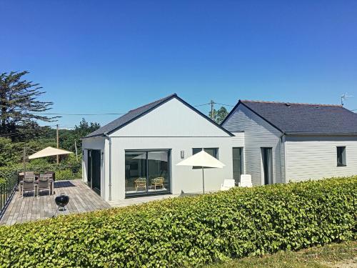 une maison blanche dotée d'une terrasse avec des chaises et des parasols dans l'établissement Maison Ranvédan à 250m de la plage - Crozon, à Crozon