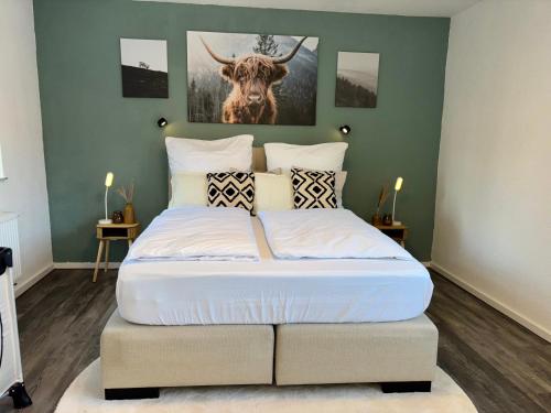 a bedroom with a bed with a deer picture on the wall at Im Herzen der Eifel - Entspannung pur in Hellenthal