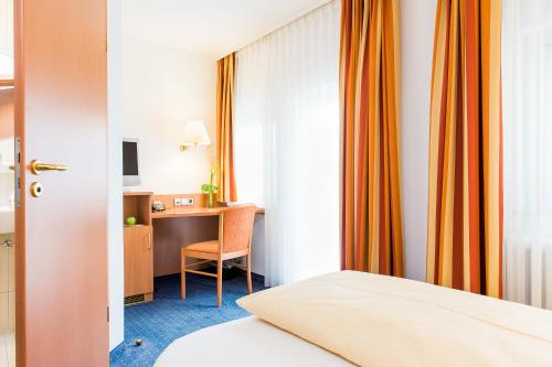 um quarto de hotel com uma cama e uma secretária em Hydepark em Haidkapelle