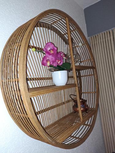 a wicker shelf with a vase and flowers on it at Vacances en tout tranquillité à Vercorin in Vercorin
