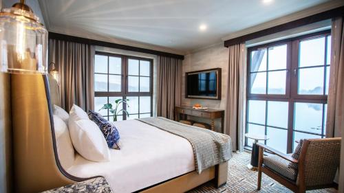a hotel room with a bed and a television at Delamar Mystic in Mystic