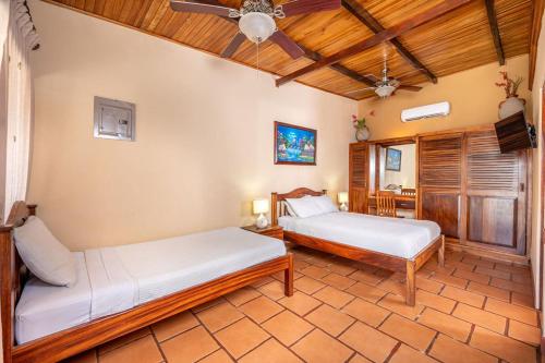 a bedroom with two beds and a ceiling fan at BP surf hotel in Refundores