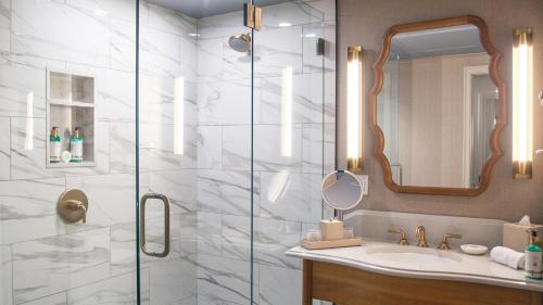 a bathroom with a shower with a sink and a mirror at Delamar Mystic in Mystic