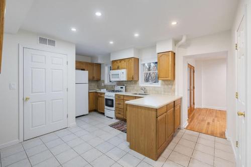 an empty kitchen with white appliances and wooden cabinets at House for groups Wifi -Hot Tub in Stony Point