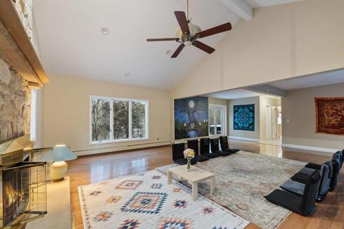 a living room with a ceiling fan and a fireplace at House for groups Wifi -Hot Tub in Stony Point