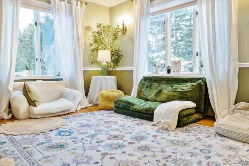 a living room with a couch and a chair and windows at House for groups Wifi -Hot Tub in Stony Point
