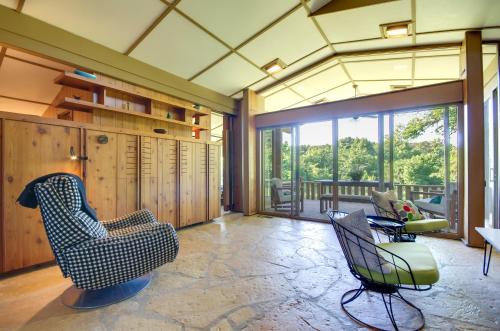 a living room with chairs and a balcony at Tranquil Mid-Century Modern Cottage with Forest View in Hardy