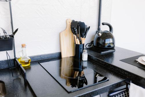 a kitchen counter with a knife block and a tea kettle at Container Experience in Jacareí