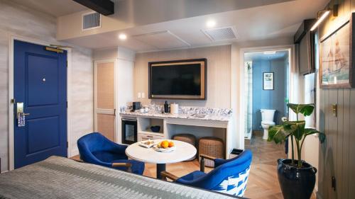 a living room with a table and chairs and a tv at Delamar Mystic in Mystic