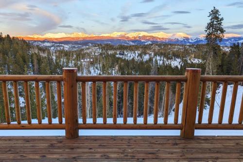 a wooden bench on a deck with a view of mountains at New Log Home, Hot Tub For 8, Views! in Tabernash