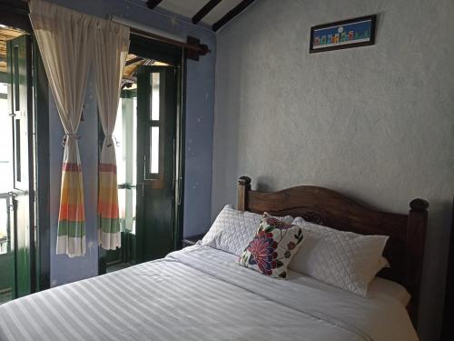 a bed with white sheets and pillows in a bedroom at Pueblito Boyacense Hotel in Duitama