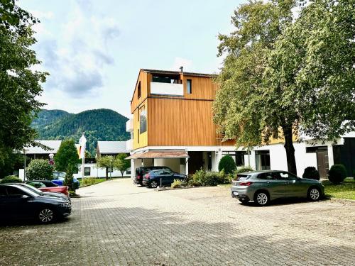 a building with cars parked in a parking lot at AlpenOase Schliersee - große Suite mit Sauna oder gemütliche Studio Appartements in Schliersee