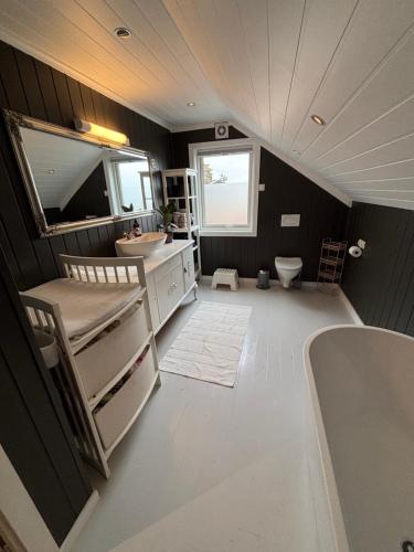 a bathroom with a tub and a sink and a toilet at Romslig familiehus på Sørlandskysten in Kristiansand