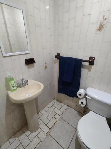 a bathroom with a white toilet and a sink at Santafe Suites in Hermosillo