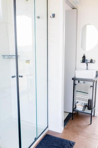 a bathroom with a shower and a sink at Container Experience in Jacareí