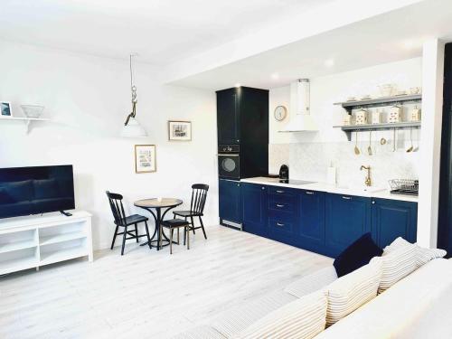 a kitchen with blue cabinets and a table and chairs at City Center Apartment in Gdańsk