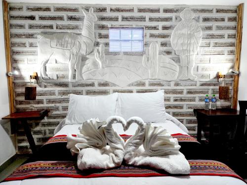 a bed with two swans shaped towels on it at Hotel Sal Andina in Uyuni