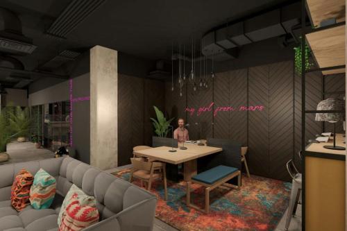 a living room with a table and a couch at Moxy Belfast City in Belfast