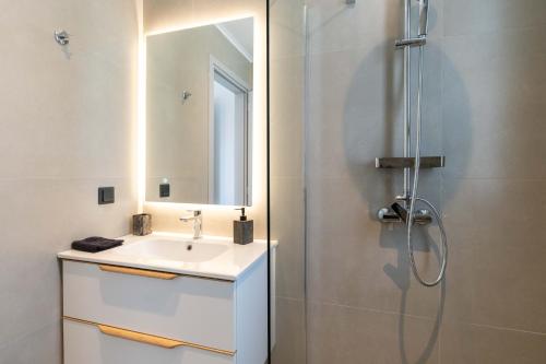 a white bathroom with a sink and a shower at Villa Nefeli in Meganisi