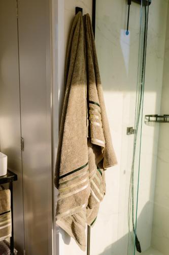 a group of towels hanging on a shower stall at Container Experience in Jacareí