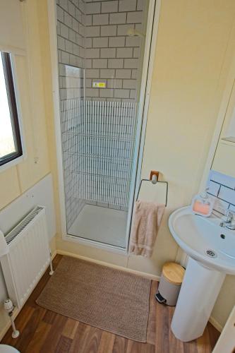 a bathroom with a shower and a sink at Ella Rose Mobile Home in Durnesh