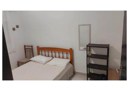 a small bedroom with a bed and a mirror at Refúgio próximo as praias de Massaguaçu e Mococa in Caraguatatuba